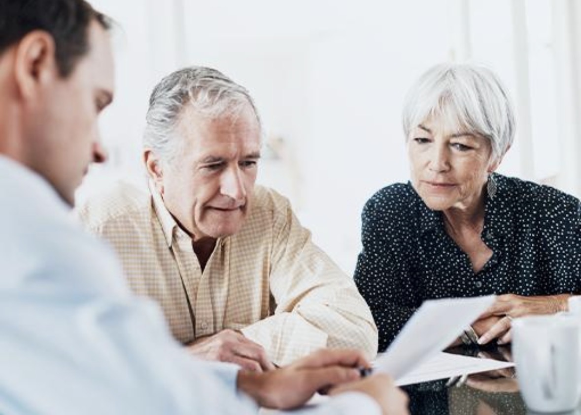 Two clients reviewing paperwork with a professional adviser